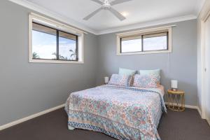 um quarto com uma cama e duas janelas em 21 Cedar Grove em Forster
