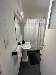 uma casa de banho branca com um lavatório e um WC em Bright apartment in Palermo em Buenos Aires