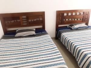 two beds sitting next to each other in a room at Casa en condominio el dorado in Trinidad