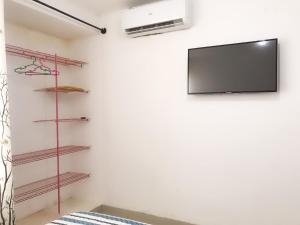 een kamer met een tv aan een muur met planken bij Casa en condominio el dorado in Trinidad