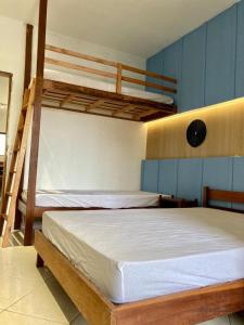 2 łóżka piętrowe w niebieskim pokoju z 2 łóżkami piętrowymi w obiekcie Apartamento Frente para o mar w mieście Ilha Comprida