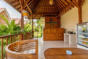 a dining room with a table and a refrigerator at Daghan Cottage Nusa Penida in Nusa Penida