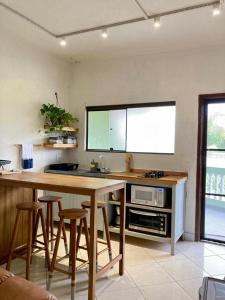 a kitchen with a table and stools in a room at Apartamento Frente para o mar in Ilha Comprida
