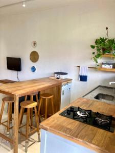 a kitchen with a stove and a wooden counter top at Apartamento Frente para o mar in Ilha Comprida