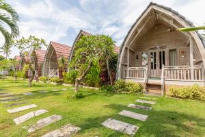 una casa con techo de gambrel y un patio en Daghan Cottage Nusa Penida en Nusa Penida