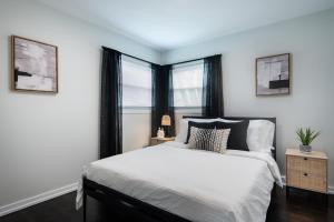 1 Schlafzimmer mit einem weißen Bett und 2 Fenstern in der Unterkunft Luxurious House, 25 min Downtown, 10min Midway in Burbank