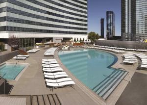 拉斯維加斯的住宿－Vdara Studio Suite 011 Pool View FREE VALET Parking，一座带躺椅的大型游泳池和一座建筑