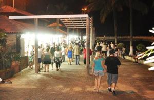 tłum ludzi chodzących nocą w obiekcie Pousada Praia Grande Solemar w mieście Praia Grande