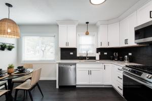 a kitchen with white cabinets and a table at Luxurious House, 25 min Downtown, 10min Midway in Burbank