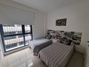 1 dormitorio con 2 camas y ventana en Somarcrisa, en Las Palmas de Gran Canaria