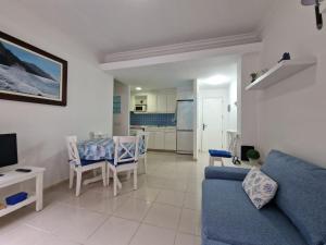 a living room with a blue couch and a table at Somarcrisa in Las Palmas de Gran Canaria