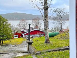 een rode schuur en een rood huis met een boom bij Holiday home Uddevalla XXIII in Uddevalla