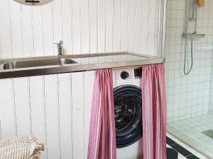 uma máquina de lavar e secar roupa debaixo de um lavatório na casa de banho em Holiday home FÄRGELANDA V em Färgelanda