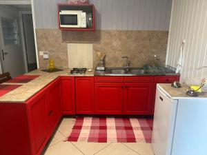 a kitchen with red cabinets and a sink at B&B Tontouta in La Tontouta