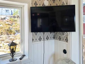 a flat screen tv on a wall with a window at Holiday home HUDDINGE II in Huddinge