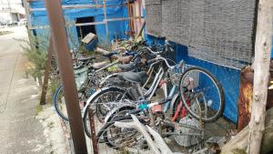 魚津的住宿－Gegege no Guesthouse - Vacation STAY 9461，一辆停在蓝色建筑旁边的自行车