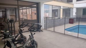 einen Fitnessraum mit Fahrrädern in einem Gebäude mit Pool in der Unterkunft GH Gran Hotel - Downtown Medellin in Medellín