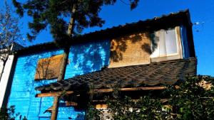 un bâtiment bleu avec deux fenêtres et un toit dans l'établissement Gegege no Guesthouse - Vacation STAY 9459, à Uozu