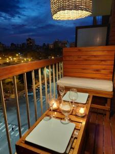 a table with wine glasses and candles on a balcony at Departamento completo para 2 personas - Esquina Plaza Mitre in Mar del Plata