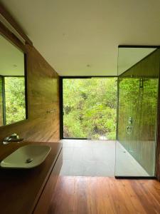 a bathroom with a glass shower and a sink at Kurunduketiya Private Rainforest Resort in Kalawana