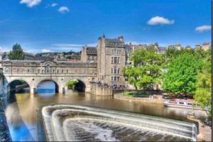 a bridge over a river in front of a building at 17A Stella house nr Bath in Radstock