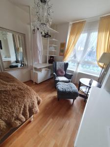 um quarto com uma cama, uma cadeira e uma mesa em Augarten Apartment em Graz