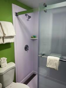 a bathroom with a glass shower with a toilet at The Aqua Pacific Hotel in Santa Cruz