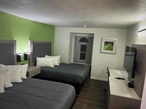 a hotel room with two beds and a flat screen tv at The Aqua Pacific Hotel in Santa Cruz