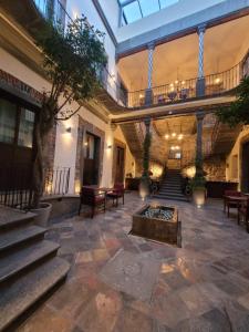 eine große Lobby mit einer Treppe und einer Feuerstelle in der Unterkunft Milo Collection Hotel in Puebla