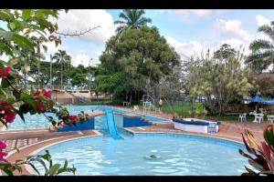 een groot zwembad met blauw water in een park bij CABAÑA 6 in Pereira