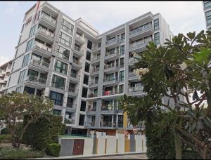 un gran edificio de apartamentos con árboles delante de él en Neo2 condo jomtrin beach, en Pattaya central