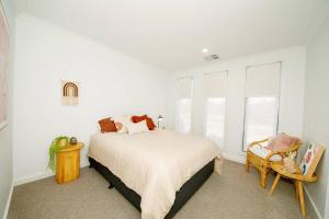 1 dormitorio blanco con 1 cama y 1 silla en 53PTCYarra, en Yarrawonga