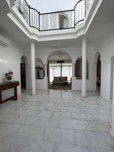 um quarto amplo com paredes brancas e um tecto com colunas em Luxury villa Near The Beach em Temara