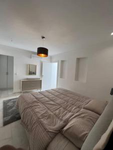 een slaapkamer met een groot bed in een witte kamer bij Luxury villa Near The Beach in Temara