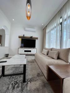 een woonkamer met een bank en een tv bij Luxury villa Near The Beach in Temara