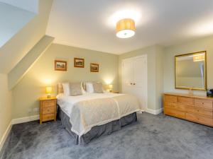 a bedroom with a bed and a mirror and a dresser at Cruives Lodge in Kiltarlty