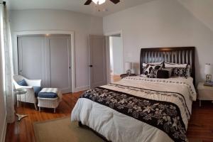 een slaapkamer met een groot bed en een stoel bij Fully Furnished Charming and Quaint New Orleans Cottage in Arabi