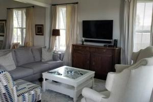 een woonkamer met een bank en een tv bij Fully Furnished Charming and Quaint New Orleans Cottage in Arabi