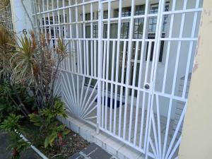 biała brama na domu z roślinami w obiekcie The Couples Inn w mieście Montego Bay