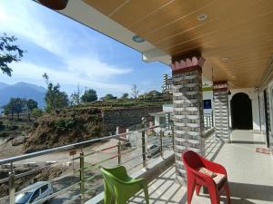 a balcony with chairs and a view of a mountain at Nature Villa in Rishīkesh