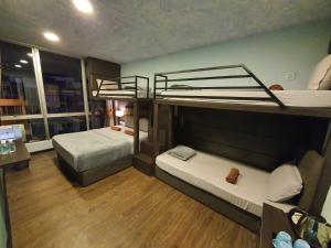 Cute Hotel & Dorms Ipoh في ايبوه: غرفة صغيرة بها سريرين بطابقين