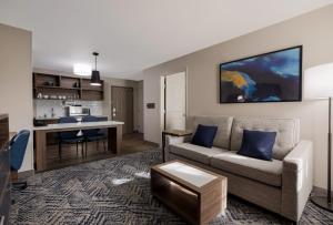 a living room with a couch and a kitchen at Candlewood Suites Lafayette - River Ranch, an IHG Hotel in Lafayette