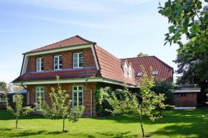 una casa de ladrillo rojo con árboles delante de ella en Apartment in Schultenbrook with garden, en Metelsdorf