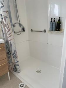 a shower in a bathroom with a shower curtain at Taree CBD boutique apartment in Taree