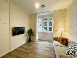 a living room with a couch and a flat screen tv at Taree CBD boutique apartment in Taree