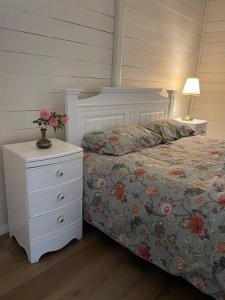 a bedroom with a bed and a nightstand with a flower arrangement on it at Taree CBD boutique apartment in Taree