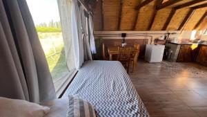 Habitación con cama y ventana con mesa. en Finca Las Liebres en San Rafael