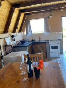 una cocina con una mesa de madera y una botella de vino en Finca Las Liebres en San Rafael