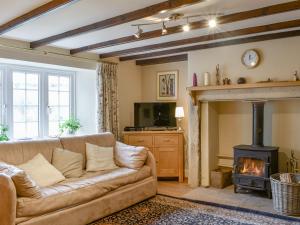 a living room with a couch and a fireplace at Black Bank House in Studdon