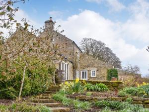 an old stone house with a garden in front of it at Black Bank House in Studdon